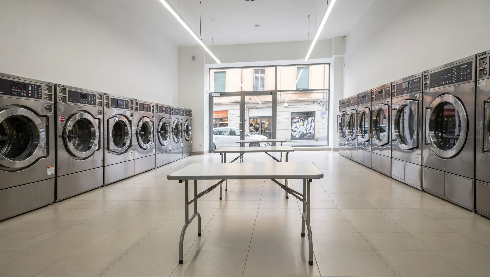 Interno di una lavanderia self-service automatica senza personale con lavatrici ed essiccatori professionali